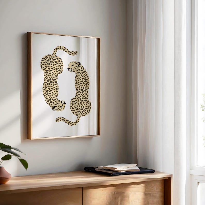 May include: A framed print of two cheetahs in a mirrored frame. The cheetahs are facing each other and are in a curled position. The background is white.