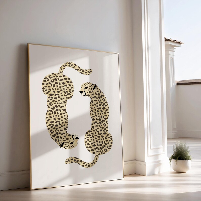 May include: A framed print of two cheetahs in a stylized design. The cheetahs are facing each other, with their bodies forming a circle. The background is white.