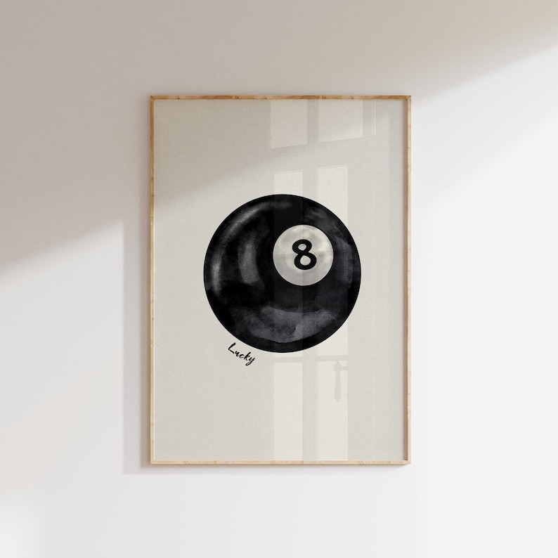 May include: A black and white watercolour illustration of a pool ball with the number 8 on it. The text "Lucky" is written below the ball.