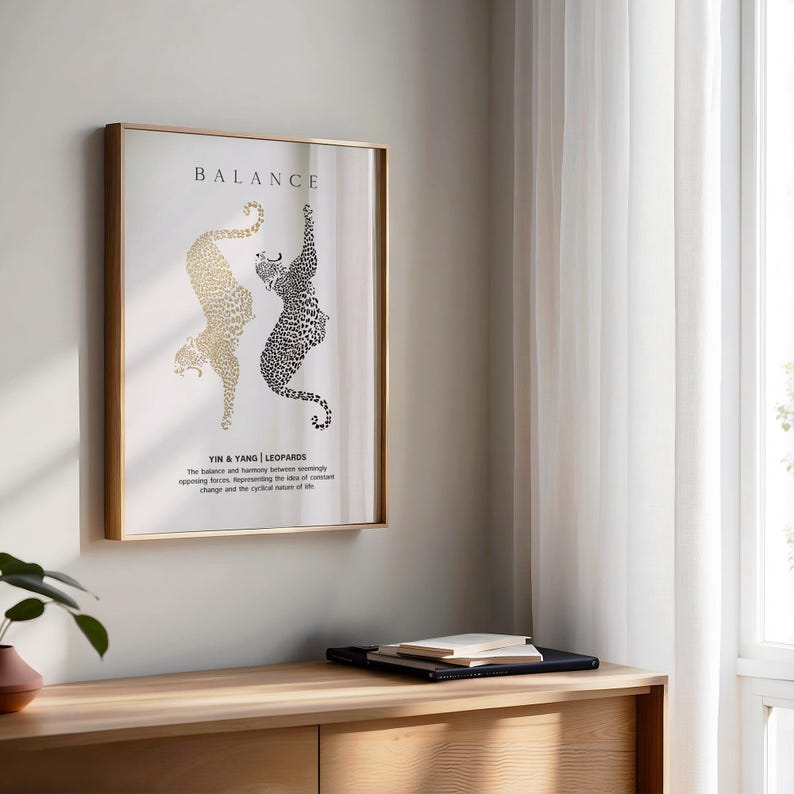 Peut inclure: Une impression encadr&eacute;e dor&eacute;e avec un fond blanc et des silhouettes de l&eacute;opards noires et dor&eacute;es. L'impression porte les inscriptions "BALANCE" et "YIN & YANG | LEOPARDS" avec une description du concept d'&eacute;quilibre.
