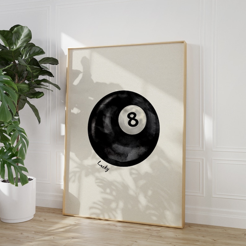 May include: A black and white watercolour illustration of a pool ball with the number 8 on it. The text "Lucky" is written below the ball.