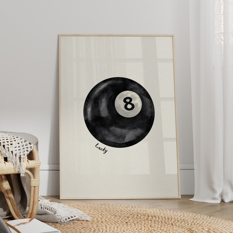 May include: A black and white watercolour illustration of a pool ball with the number 8 on it. The text "Lucky" is written below the ball.