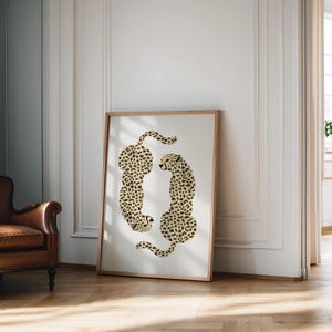 May include: A framed print of two cheetahs in a beige and brown spotted pattern, facing each other in a circular shape.