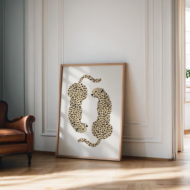 May include: A framed print of two cheetahs in a beige and brown spotted pattern, facing each other in a circular shape.
