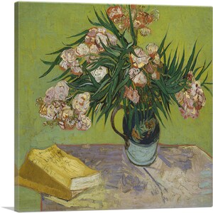 May include: A still life painting by Vincent van Gogh featuring a bouquet of pink oleander flowers in a blue ceramic vase, with a yellow book on a table with a white tablecloth.