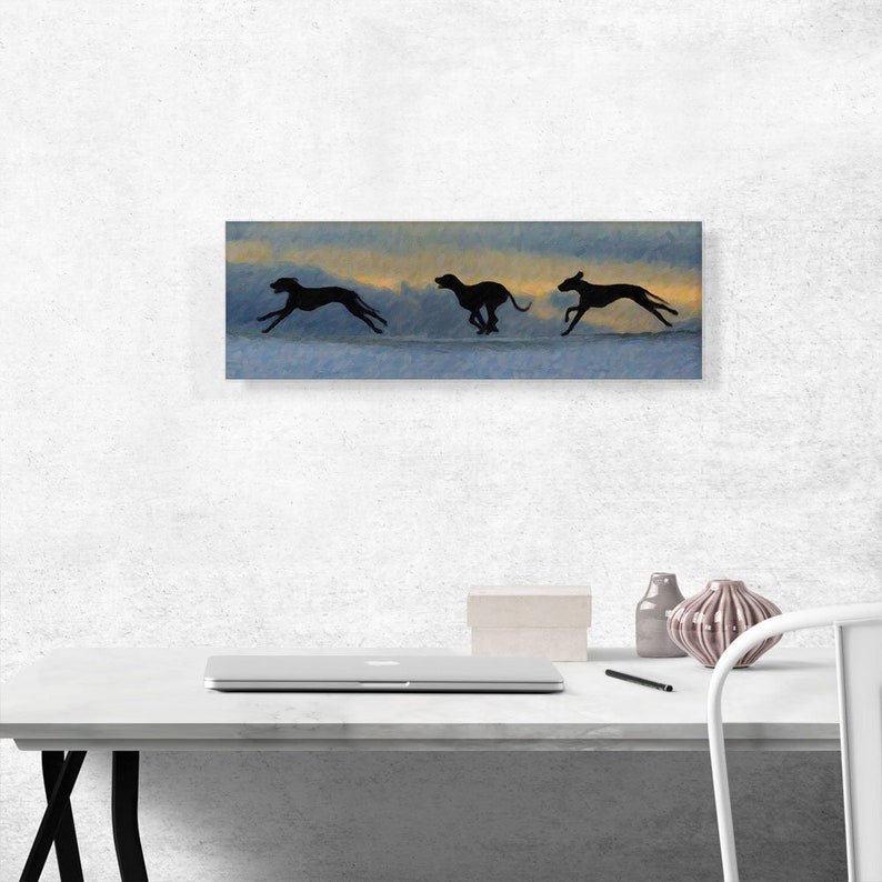 May include: Three black silhouettes of dogs running across a blue and orange sky. The dogs are running in a line, with the first dog in the lead and the last dog in the back. The sky is a gradient of blue and orange, with clouds in the background.