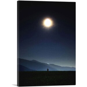 ARTCANVAS Hombre de pie mirando la luna brillante en la noche Lienzo impreso