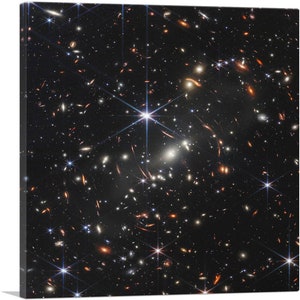 May include: A black and white photograph of a star-filled galaxy with a bright star in the center. The galaxy is filled with many smaller stars and galaxies.