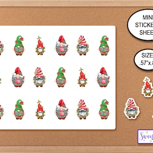 May include: A sheet of 18 mini Christmas gnome stickers, each gnome wearing a red hat and a green wreath. The stickers are on a white background and measure .57" x .8". The sheet is labeled "Mini Stickers Sheet" and "Size: .57" x .8" ".