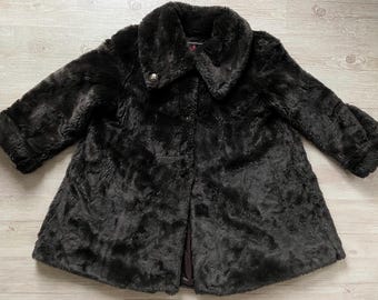 May include: A black faux fur coat with a large collar and a button closure. The coat has a soft, plush texture and a classic design.