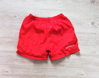 Könnte beinhalten: Rote Sport-Shorts mit einem weißen "AUSTRIACO"-Logo.