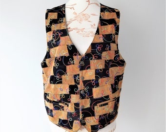 May include: A brown and black patchwork waistcoat with colourful embroidery. The waistcoat has a chequered pattern and a V-neck.