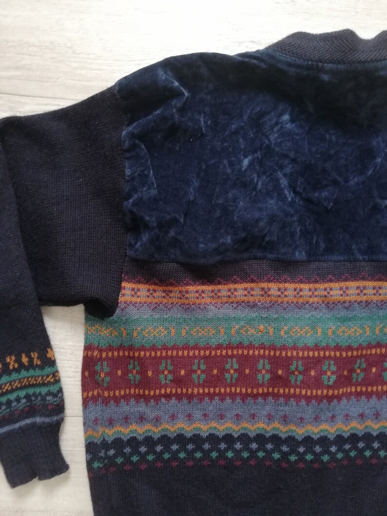May include: A dark blue sweater with a colorful geometric pattern and a dark blue velvet patch on the back.