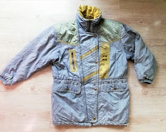 May include: A blue and yellow vintage ski jacket with a zip closure and a drawstring waist. The jacket has a quilted design and a contrasting yellow panel on the front.