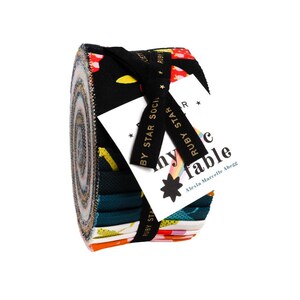 May include: A rolled fabric bundle featuring a variety of colorful patterns, including floral and geometric designs. The bundle is secured with a black ribbon and a tag that reads "my fable" and "Ruby Star".