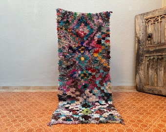 May include: A colourful Moroccan rug with a geometric pattern. The rug is made of wool and has a fringe on the ends.