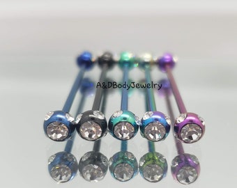 May include: A set of six surgical steel barbell body jewelry with clear crystal gems. The barbells are in various colors, including blue, green, purple, and black.