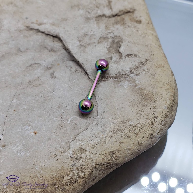 May include: A rainbow iridescent barbell with two round balls on each end. The barbell is made of surgical steel and is a popular choice for body piercings.