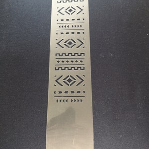 May include: A metal stencil featuring a range of geometric patterns, including diamonds, triangles, and zigzags. The stencil is designed for crafting and decorating projects.