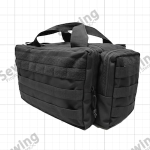 Op de afbeelding: Zwarte tactische tas met meerdere compartimenten en een handvat aan de bovenkant. De tas heeft MOLLE-banden voor het bevestigen van extra zakjes en accessoires. Het heeft een voorvak met ritssluiting en klittenband.