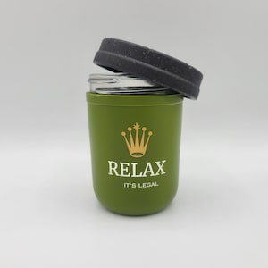 Könnte beinhalten: Ein grünes Glasgefäß mit einem schwarzen Deckel und einem goldenen Kronenlogo. Auf dem Gefäß steht "Relax It's Legal".