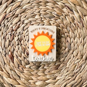 May include: A wooden sign with a sun graphic and the text "You're a sensational teacher. Thank you for letting me shine."