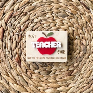 May include: Wooden sign with a red apple and the text "Best Teacher Ever" and "Thank you for putting your heart into teaching".