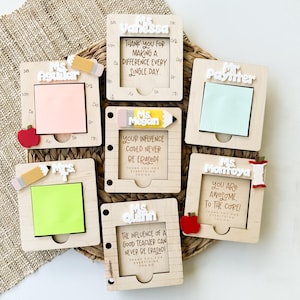 May include: Six wooden notepads with personalized messages for teachers. Each notepad has a different teacher's name, a small pencil or apple decoration, and a message of appreciation. The notepads are on a woven brown background.