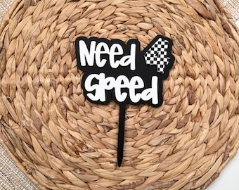 May include: Black and white cake topper with the text "Need 4 Speed" and a checkered flag.