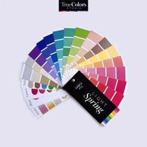 Könnte beinhalten: Ein Farbpalette-Fächer mit einem schwarzen Etikett, auf dem "True Colors Studio" und "LIGHT SPRING" steht. Der Fächer ist geöffnet, um eine Vielzahl von Farben zu zeigen, darunter Farbtöne von Rosa, Rot, Gelb, Grün, Blau und Lila.