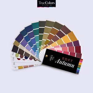 Peut inclure: Un éventail de palette de couleurs avec une couverture noire qui dit "True Colors Studio" et "Soft Autumn". L'éventail a 20 échantillons de couleurs dans des nuances de brun, vert, bleu, violet et rouge.