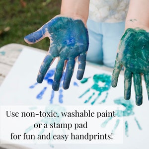 May include: Two hands covered in blue and green washable paint making handprints on a white surface. The text "Use non-toxic, washable paint or a stamp pad for fun and easy handprints!" is below the handprints.