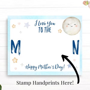 May include: A blue and white card with the text "I love you to the moon" and a smiling moon face. The card has a space for handprints and the text "Happy Mother's Day!"