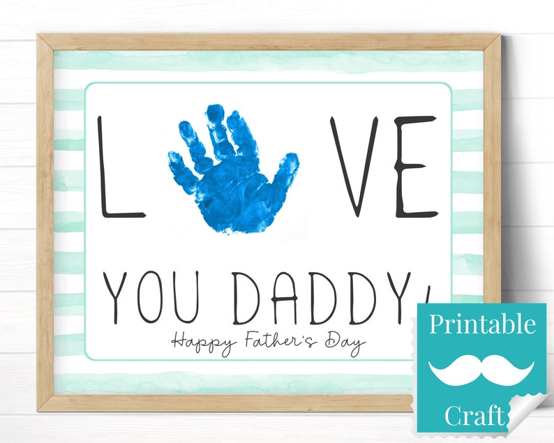 May include: Printable craft for Father's Day. A blue handprint with the word "LOVE" on either side and the text "YOU DADDY" below. The text "Happy Father's Day" is below the handprint. The text "Printable Craft" is in a blue box with a white mustache.