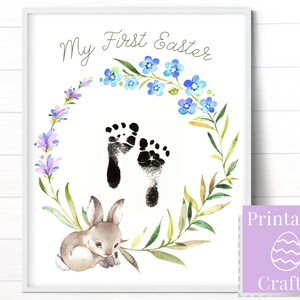 May include: Printable Easter footprint art with a watercolor wreath of blue flowers and green leaves. The text "My First Easter" is at the top of the print. A small brown bunny is at the bottom of the print.
