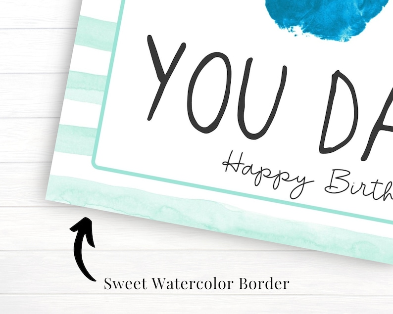May include: A light blue watercolor border with white stripes surrounds a white card with the text "You Da" and "Happy Birth".