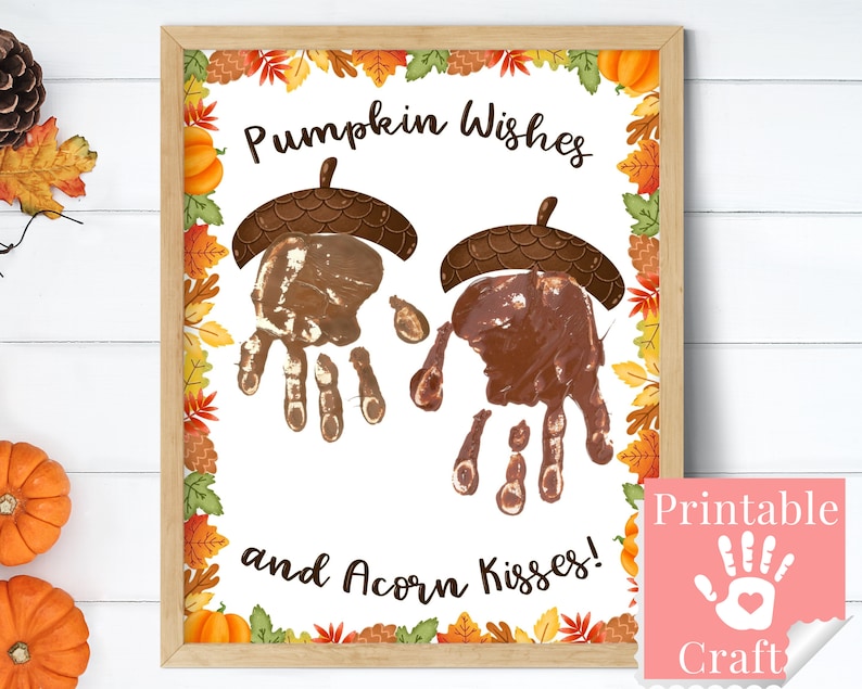 May include: Printable craft for kids featuring handprints in the shape of pumpkins and acorns. The text reads "Pumpkin Wishes and Acorn Kisses!" with a fall-themed border.