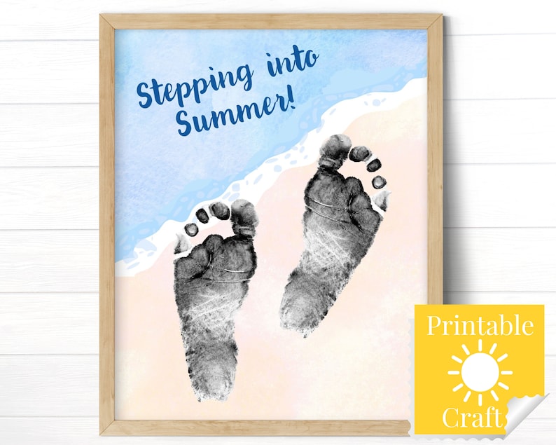 Op de afbeelding: Printbare knutsel met een aquarel achtergrond van een strand sc&egrave;ne. De tekst "Stepping into Summer!" is in blauw geschreven. Twee zwarte baby voetafdrukken zijn op het zand.