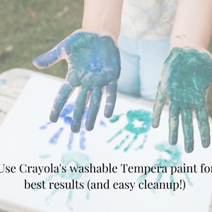 Pu&ograve; includere: Due mani con vernice blu e verde, che lasciano impronte di mani su una tela bianca. Il testo "Use Crayola's washable Tempera paint for best results (and easy cleanup!)" &egrave; visibile nella parte inferiore dell'immagine.