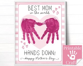 Può includere: Una stampa verticale incorniciata con un grande cuore rosa chiaro sullo sfondo e due impronte di mani rosa scuro che formano un cuore. Il testo recita BEST MOM in the world, HANDS DOWN! e Happy Mother's Day, con piccoli cuori rosa.