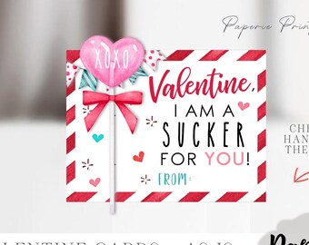 May include: A printable Valentine's Day card featuring a pink heart lollipop with the words "XOXO" on it. The card says "Valentine, I am a sucker for you!" with a space to write "from:" below. The card has a red and white striped background with hearts and stars.