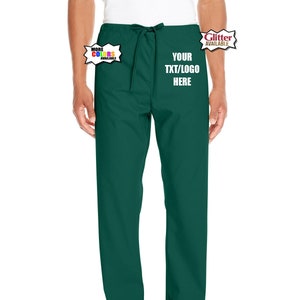 Puede incluir: Pantalones de uniforme médico de color verde oscuro con cintura elástica y cordón. La parte delantera presenta el texto en blanco YOUR TXT/LOGO HERE. Hay dos gráficos de burbujas de diálogo, uno que dice MORE COLORS AVAILABLE y otro GLITTER AVAILABLE.