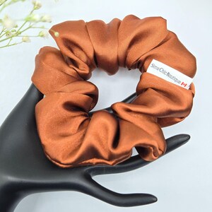 May include: A brown satin scrunchie with a white label that reads "Sims Chic Boutique" and a Canadian flag.