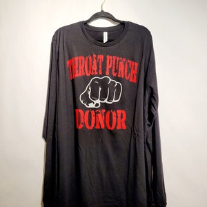 May include: Black long-sleeved t-shirt with a red graphic print that says "Throat Punch Donor" with a white fist in the middle of the text.