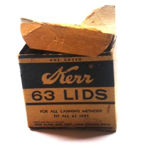 May include: A vintage cardboard box for Kerr 63 lids, featuring a tan and black color scheme. The text reads One Dozen, Kerr 63 Lids, For All Canning Methods, Fit All 63 Jars, and Kerr Glass Mfg. Corp., Sand Springs, Okla. The top flap is open.