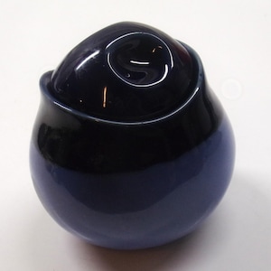 May include: A two-tone ceramic jar with a lid. The jar is a deep navy blue at the top, transitioning to a lighter blue at the base. The lid has a rounded shape with a glossy finish. The jar is likely used for storage.