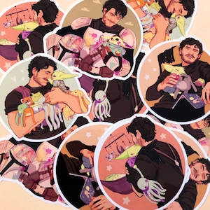 May include: A set of nine round stickers featuring a cartoon character with brown hair and a black shirt holding various plush toys. The toys include a green alien, a purple octopus, a pink bunny, and a green frog. The stickers have a white border and a light pink background with white stars.