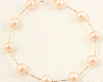 Pulsera de oro amarillo de 14 k con tubo retorcido y perla cultivada rosa