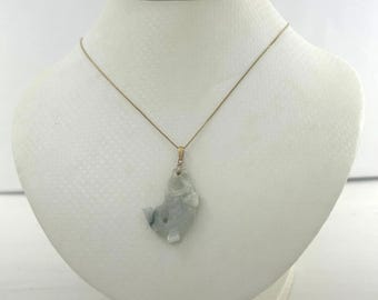 May include: A gold-toned necklace featuring a pendant shaped like a fish. The fish pendant is a pale blue-green color with darker green accents. The necklace is displayed on a white mannequin.