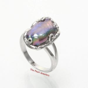 May include: A silver ring featuring a large, iridescent pearl with shades of purple, green, and pink. The pearl is set in a decorative silver setting. The text "The Pearl Jewelers" is at the bottom.